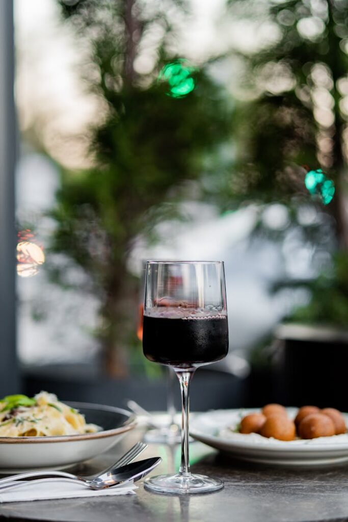 A glass of wine and a plate of food on a table