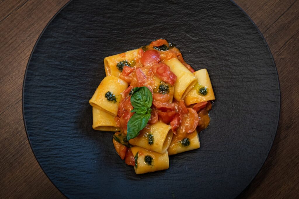 A plate of pasta with tomatoes and basil